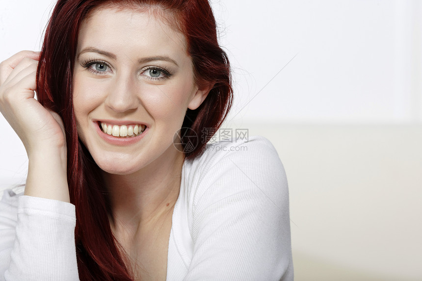 年轻女性在家放松红色休息室快乐微笑女士头发客厅休息白色图片