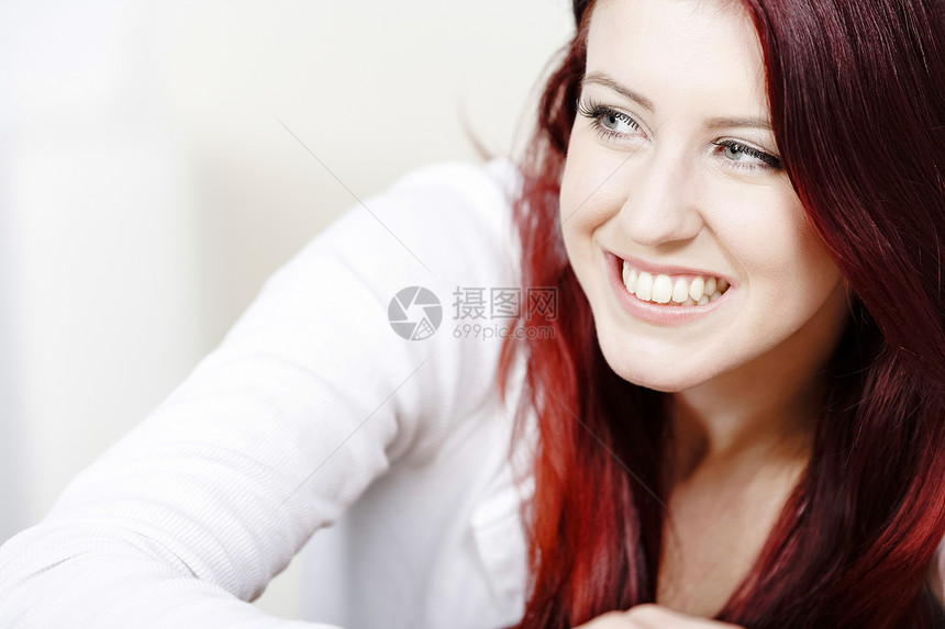 年轻女性在家放松头发红色微笑休息客厅女士快乐白色休息室图片