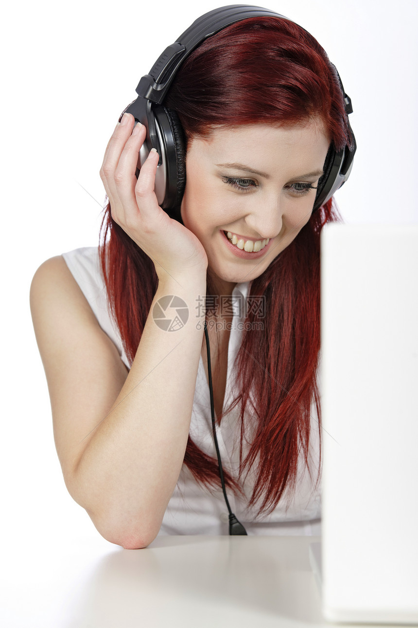 使用笔记本电脑手持耳机的妇女女士红色音乐微笑快乐女性头发图片