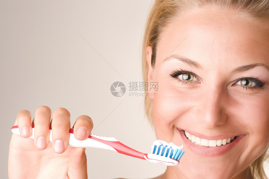 快乐的青年女子刷牙微笑女孩金发牙膏白色头发牙科牙齿美丽刷子图片