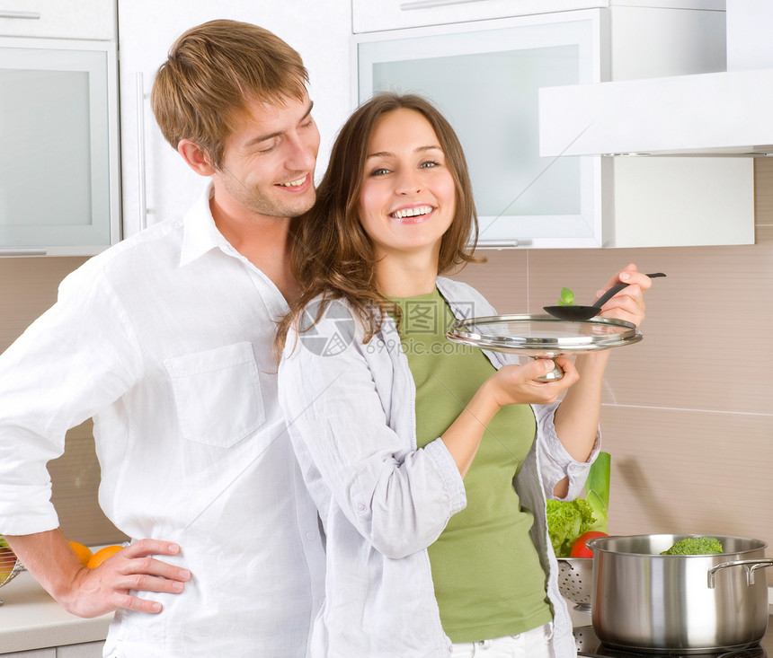 年轻幸福的情侣一起在家厨房做饭女士微笑家庭烹饪男性男人蔬菜妻子勺子工作图片