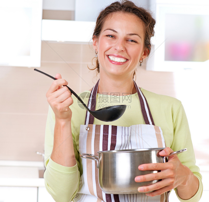 年轻妇女烹饪健康食品牙齿微笑生活金属蔬菜食谱沸腾幸福妻子房子图片
