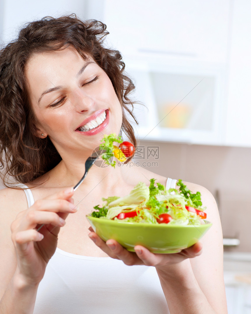 美丽的吃蔬菜的女青年食用蔬菜沙拉厨房微笑食物女孩女性午餐早餐损失身体重量图片