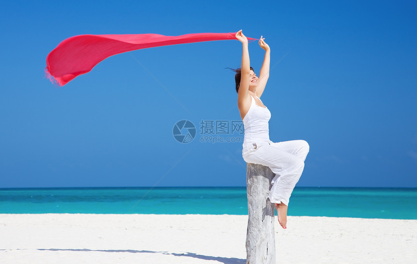 在海滩上快乐的女人围裙乐趣蓝色晴天活力幸福天空天堂福利海洋图片