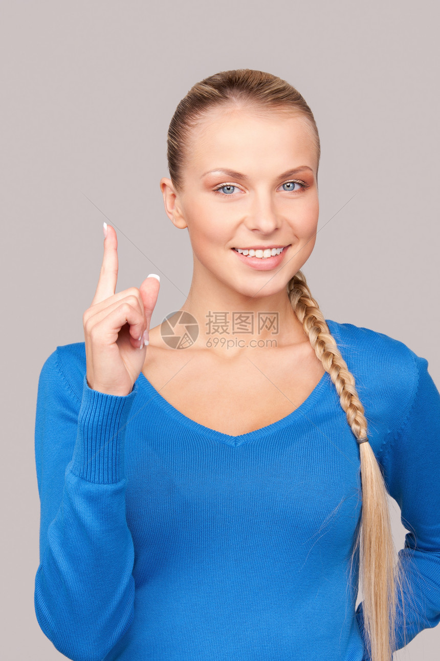 女人的手指举起她的手指注意力女孩手势微笑蓝色公告人士女性手臂生长图片