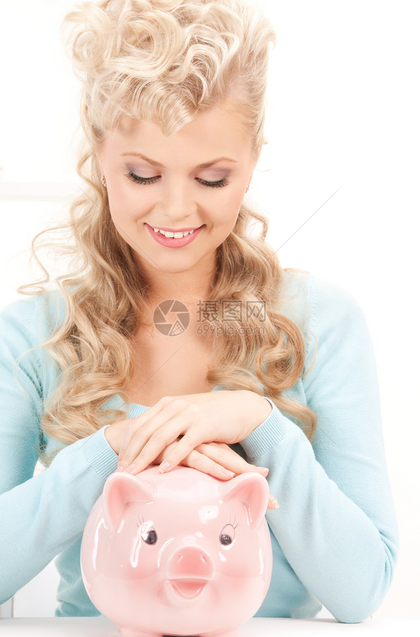 可爱的有小猪银行的女人蓝色成人微笑小猪幸福女孩快乐投资经济银行图片
