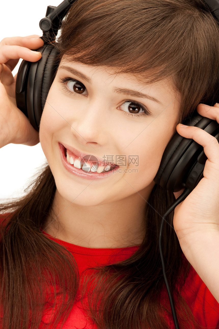 使用大耳机的快乐少女青少年女性微笑幸福手机耳机乐趣音乐播放器闲暇女孩图片