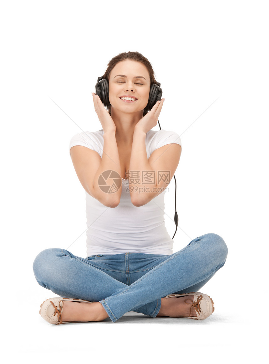 使用大耳机的快乐少女喜悦青少年幸福音乐播放器闲暇微笑享受女孩音乐听力图片