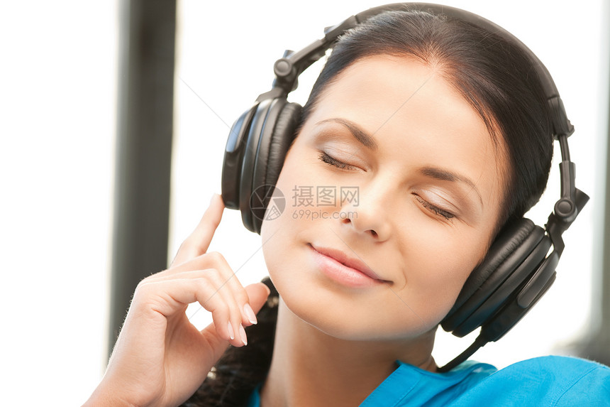使用大耳机的快乐少女音乐手机女性享受幸福耳机听力青少年音乐播放器喜悦图片