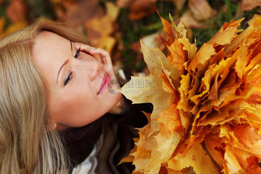 秋叶中的妇女脚尖头发橙子幸福感恩女性团体乐趣女士叶子季节图片