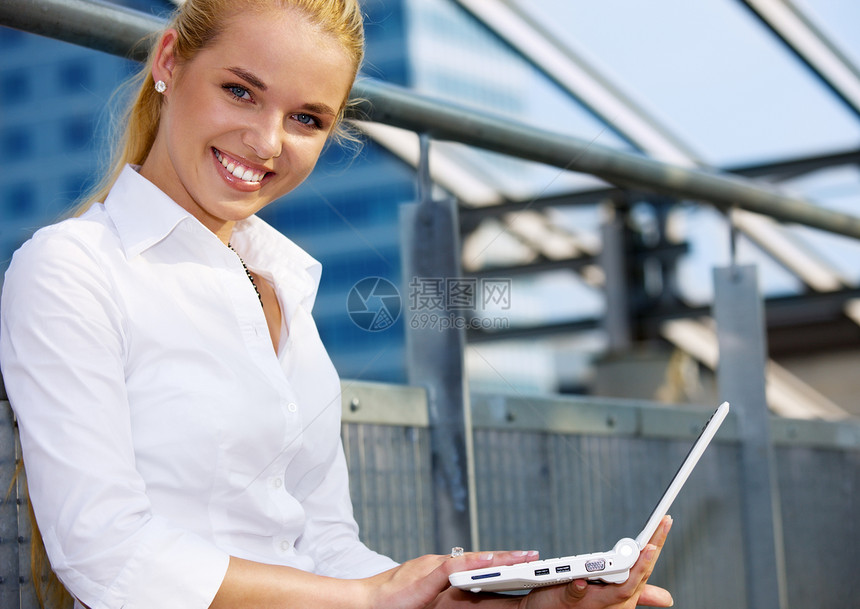 携带膝上型电脑的妇女微笑学生笔记本晴天蓝色皮士衣领环境女士女性图片