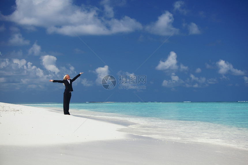 海洋海岸上快乐的女商务人士女性阳光蓝色旅行假期海浪金发女郎微笑女孩套装图片