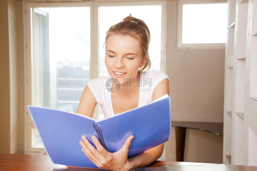 快乐和笑笑的少女 用大笔记本记事本学生软垫教育文书微笑学校青少年工作笔记图片