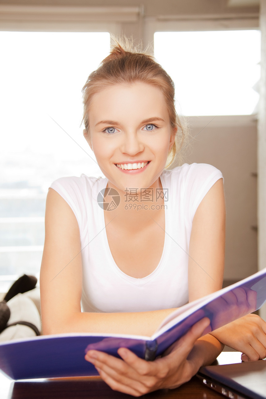 快乐和笑笑的少女 用大笔记本享受学生青少年家庭作业阅读女性文书工作记事本笔记图片
