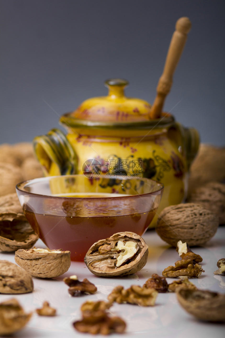 蜜杯和胡桃民间手工食物蜂蜜玻璃液体反射棕色黄色核桃图片
