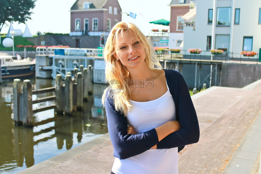 荷兰Gorinchem镇水边的女孩 尼瑟兰女性夹克裙子码头城市地标美丽假期旅游房子图片