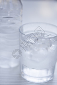 瓶子和桌上玻璃中的新鲜冷清水矿泉水白色产品矿物苏打食物宏观酒吧流动生活饮料背景图片