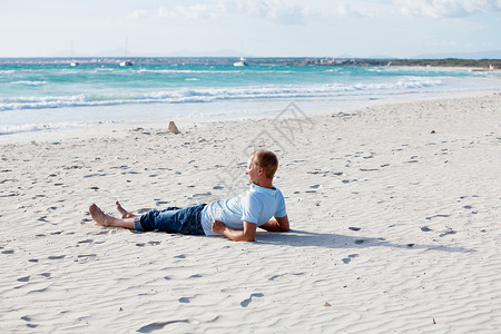 青年男子在暑假的沙滩上放松男人假期旅行阳光成人快乐蓝色海滩力量身体背景图片