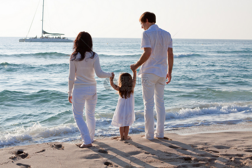 快乐的年轻家庭 和女儿在沙滩上男性父母孩子假期成人团体女士女孩蓝色旅行图片