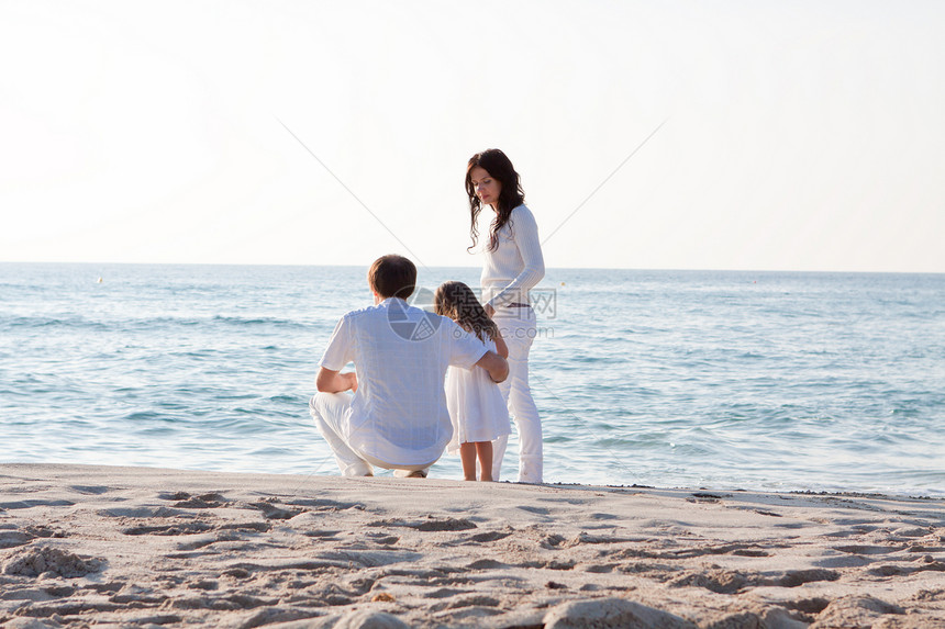 快乐的年轻家庭 和女儿在沙滩上女士乐趣成人母亲团体女孩旅游幸福假期海滩图片