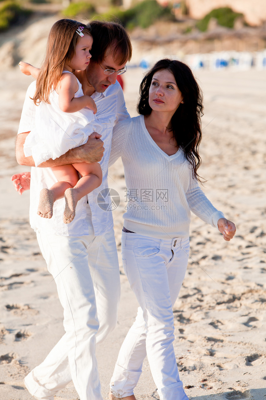 快乐的年轻家庭 和女儿在沙滩上乐趣父亲母亲假期旅游女性孩子旅行女孩喜悦图片