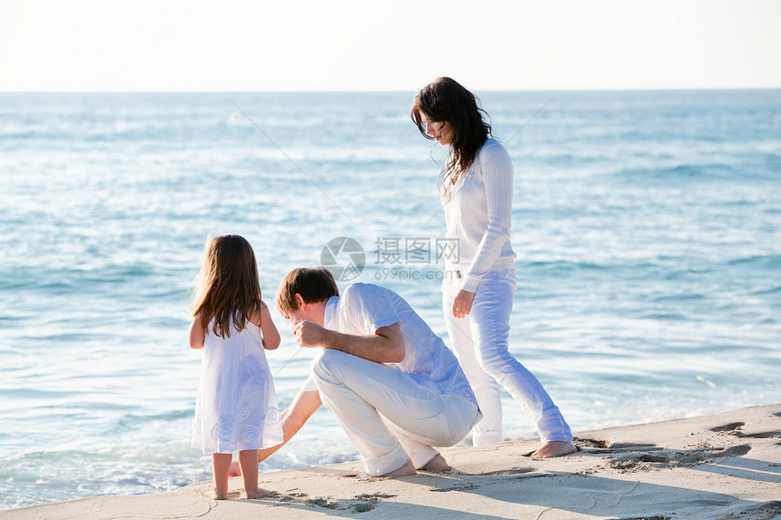 快乐的年轻家庭 和女儿在沙滩上成人喜悦女性团体女士旅行父母母亲乐趣孩子图片