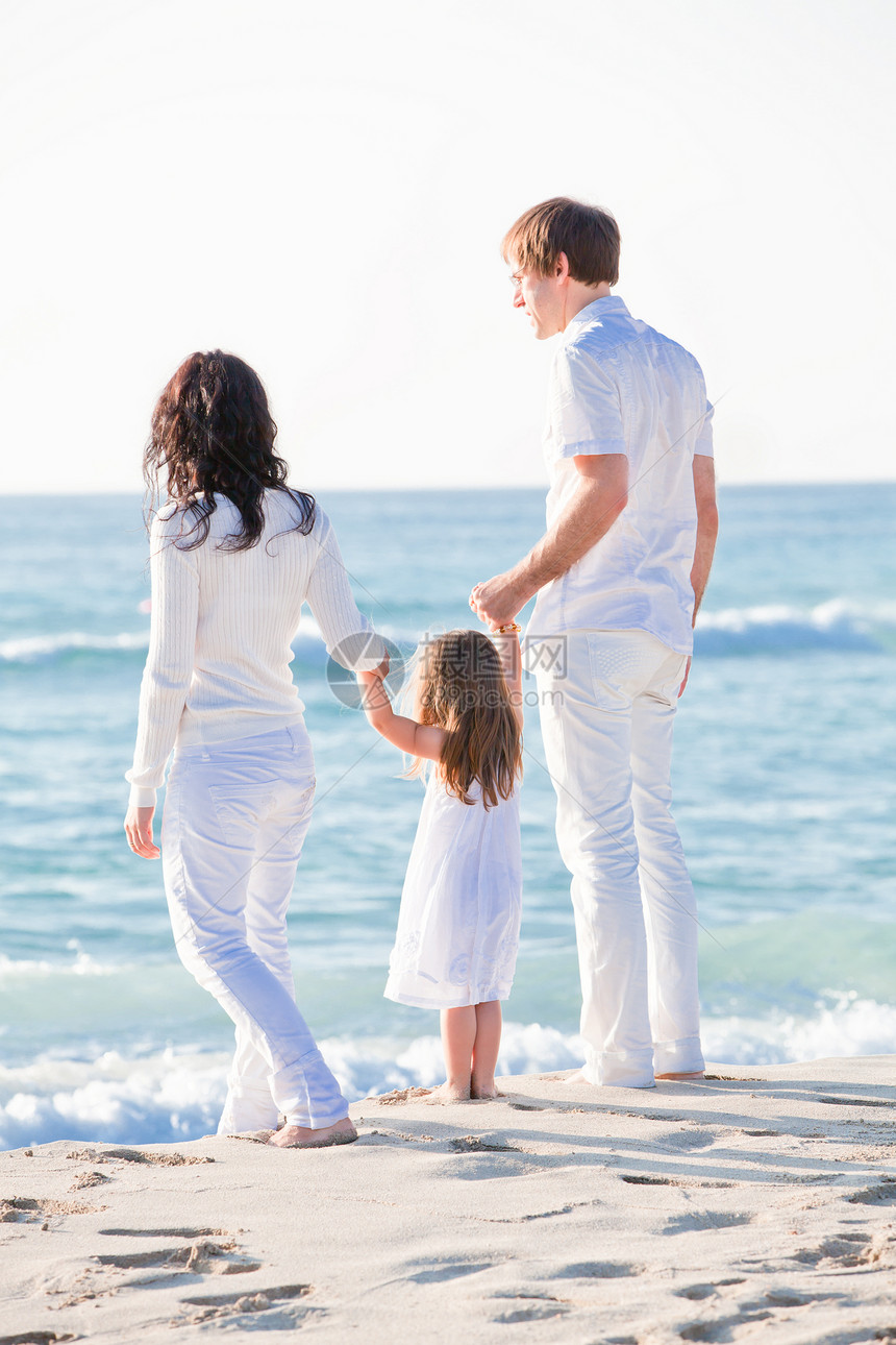 快乐的年轻家庭 和女儿在沙滩上母亲成人海滩女孩男人旅行男性孩子乐趣幸福图片