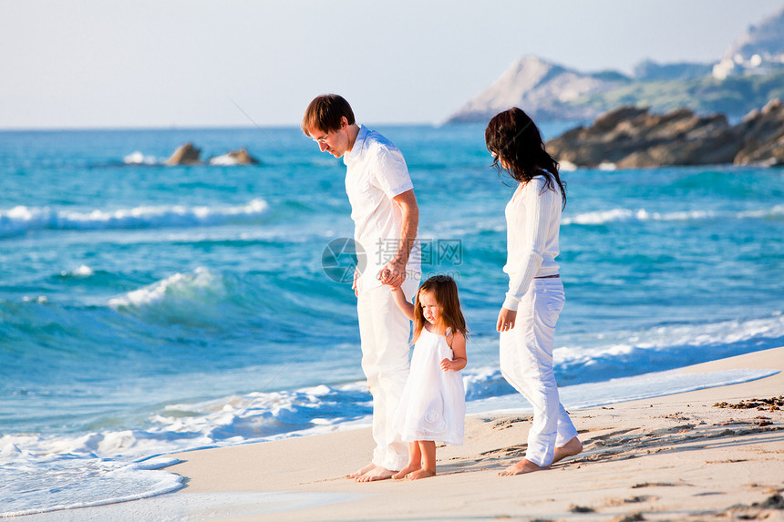快乐的年轻家庭 和女儿在沙滩上旅行幸福海滩旅游女性成人男性父亲假期团体图片