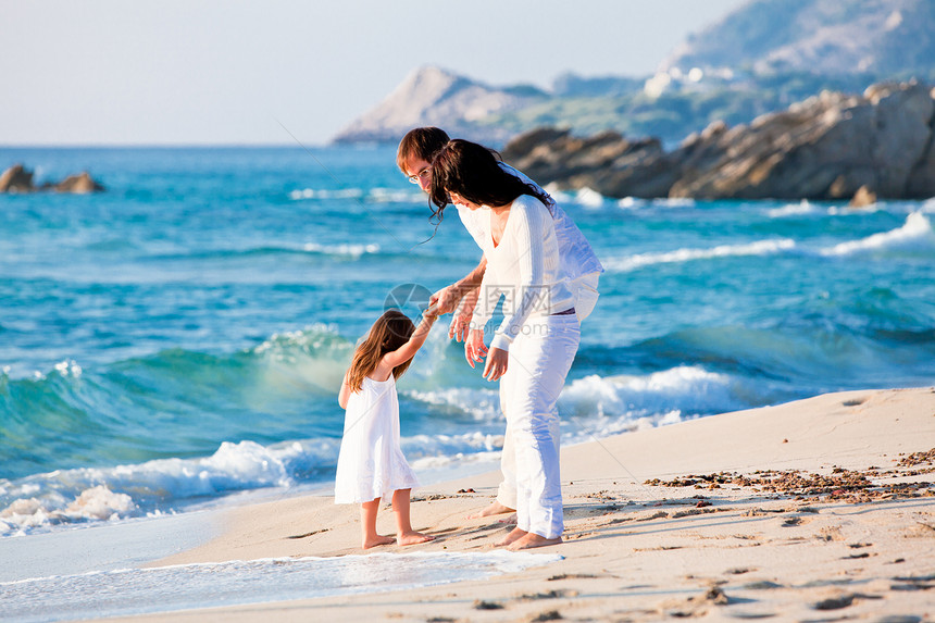 快乐的年轻家庭 和女儿在沙滩上海滩乐趣喜悦假期女性旅游父母孩子男性成人图片