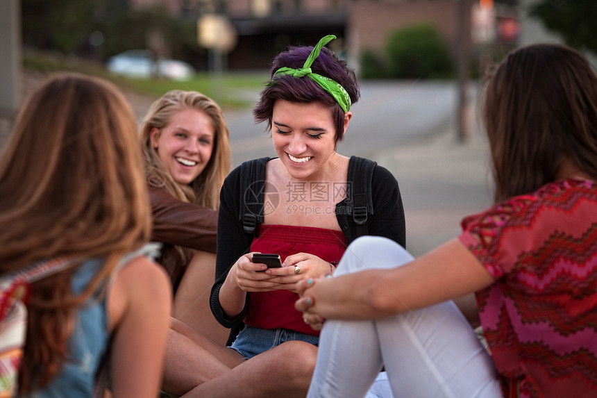 西班牙裔青少年与朋友和电话图片
