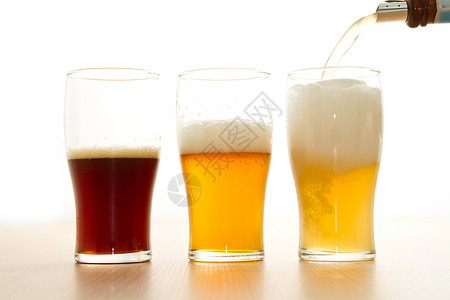 贮藏啤酒白色背景上有不同啤酒的玻璃杯背景