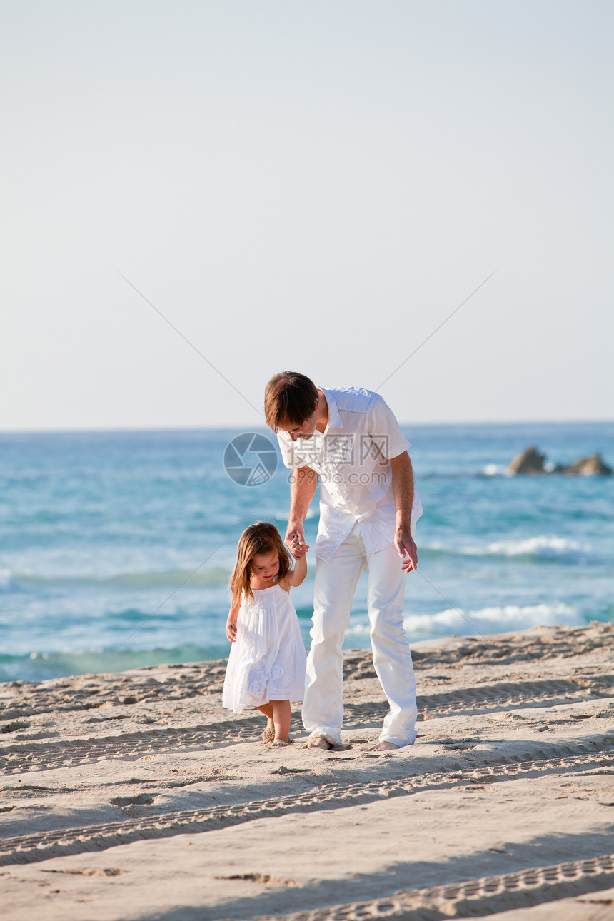 幸福的家父和女儿在海滩上玩得开心享受拥抱喜悦男人童年微笑快乐男性乐趣家庭图片