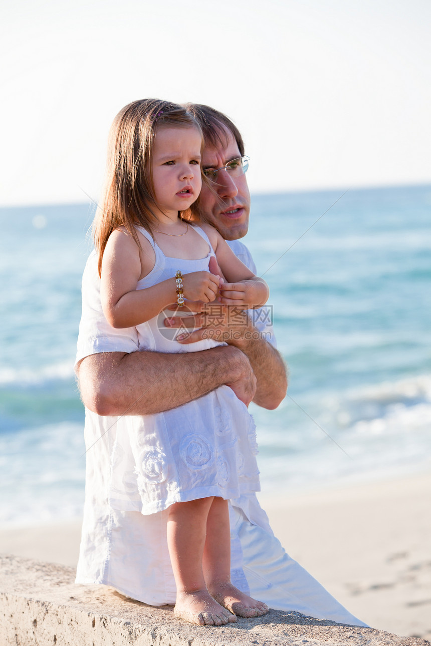 幸福的家父和女儿在海滩上玩得开心父亲拥抱乐趣快乐假期家庭成人童年女孩享受图片