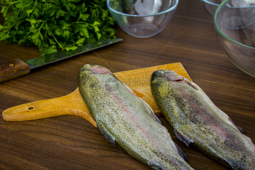 两只生鳟鱼尾巴香菜海鲜钓鱼美食食物健康绿色海洋午餐图片