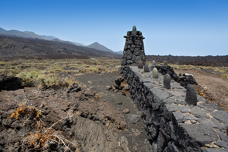La Palma熔岩石栅栏柱自然栅栏土地石头石工天空岩石假期沙漠干旱背景图片