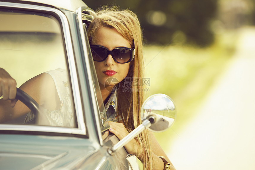 坐在车里的年轻美女太阳镜运输女性模特蓝色成人交通头发方式时装图片