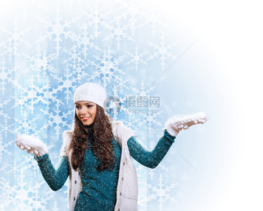 穿着温暖毛衣的年轻妇女围巾帽子雪花乐趣女性快乐化妆品衣服眼睛季节图片