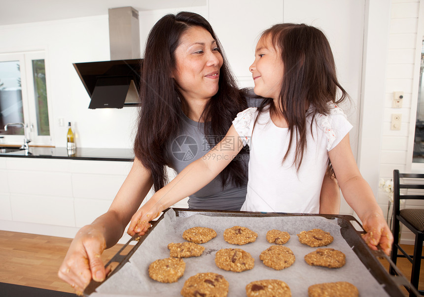 母亲和女儿烘烤饼干女孩乐趣面粉面团童年家庭厨房展示食物平底锅图片