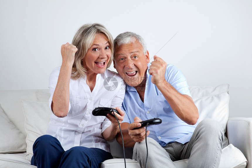 玩电子游戏的情侣女性丈夫微笑游戏乐趣朋友闲暇享受女士养老金图片