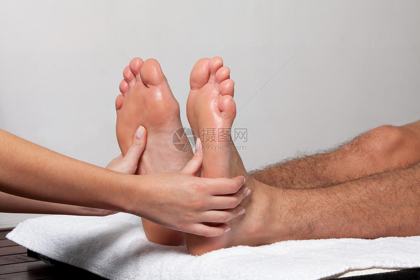 男子接受脚部按摩男人女士治疗男性手指皮肤药品按摩师护理说谎图片
