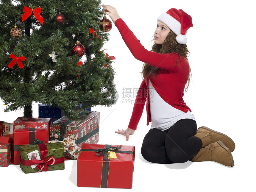 女士把球装饰 在圣诞节树上图片