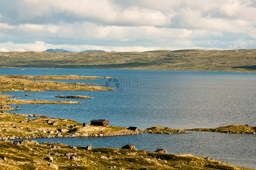 在挪威某处的峰顶上的湖屋图片