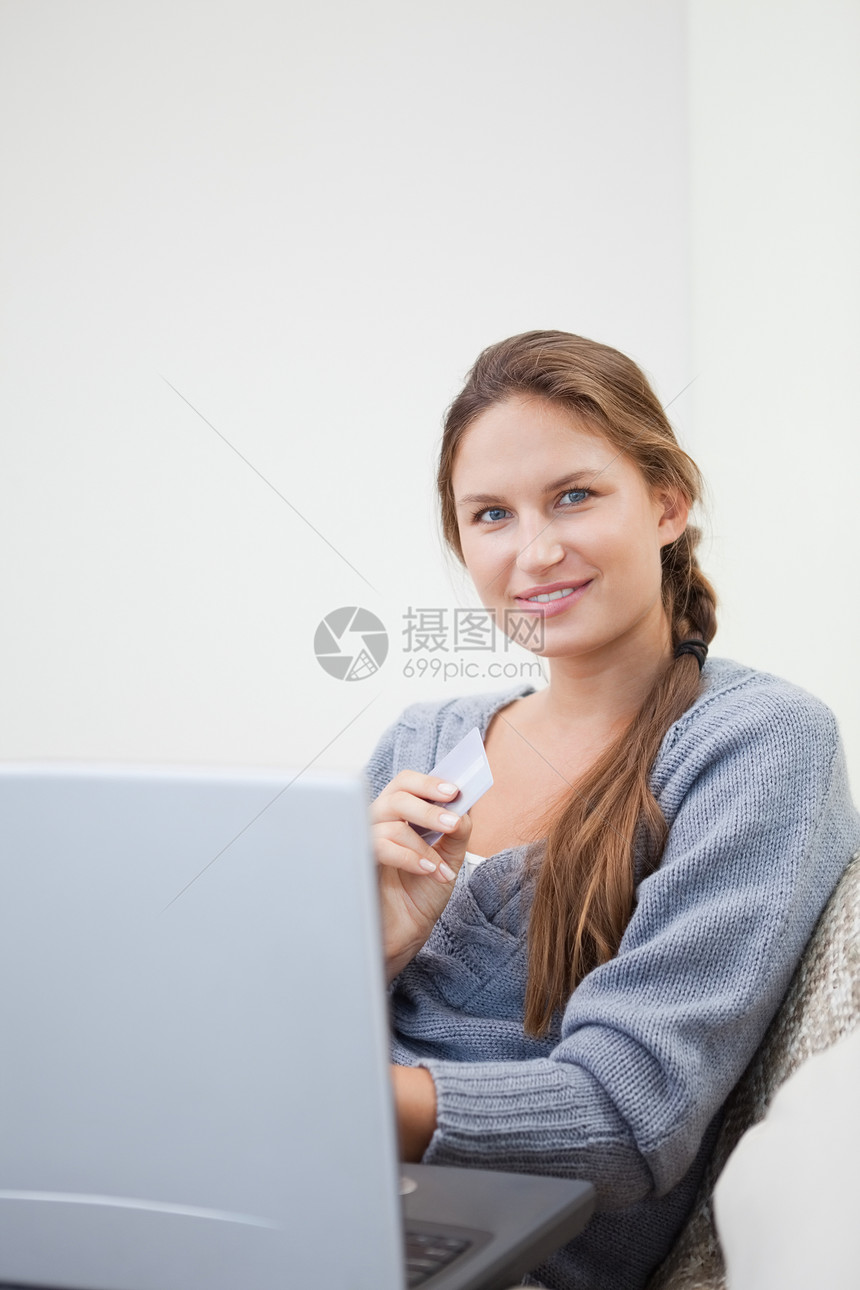 妇女使用平板电脑时坐着图片