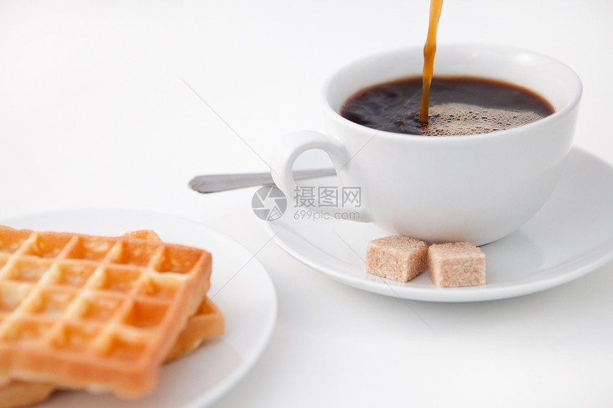 松饼糖和一杯咖啡在白色盘子上图片