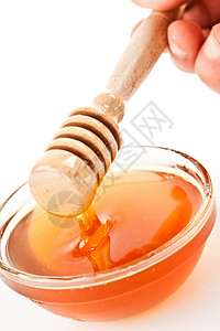 蜂蜜在碗的顶端 降蜂蜜背景图片