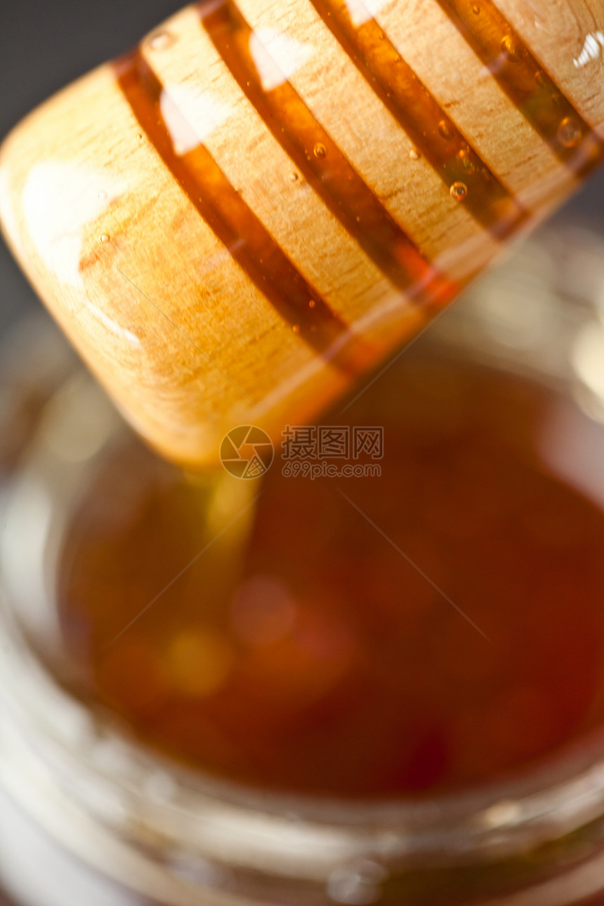蜂蜜罐子上方的蜂蜜图片