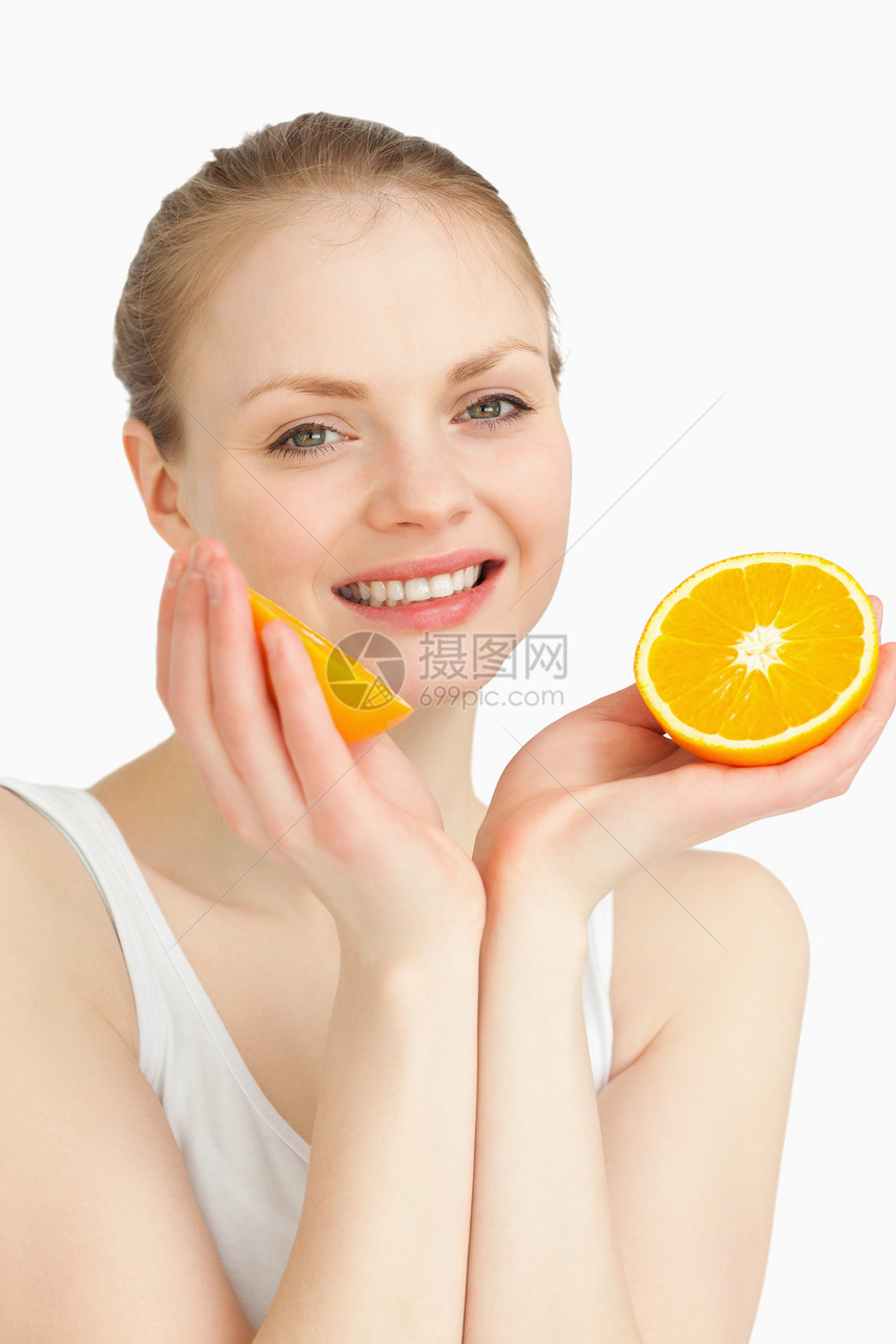 开心的女子在微笑时拿着橙子图片