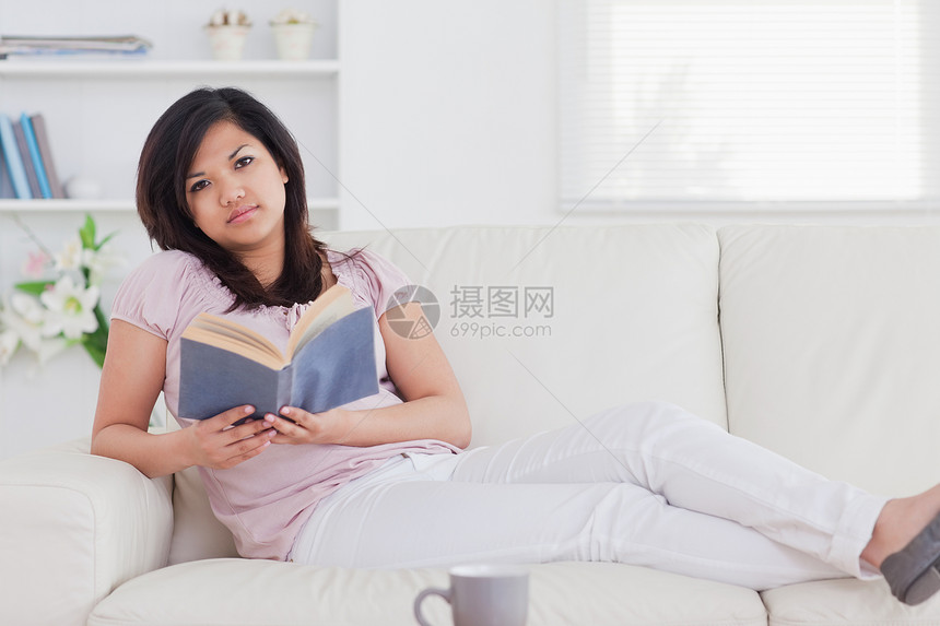 女人躺在沙发上 拿着一本书图片