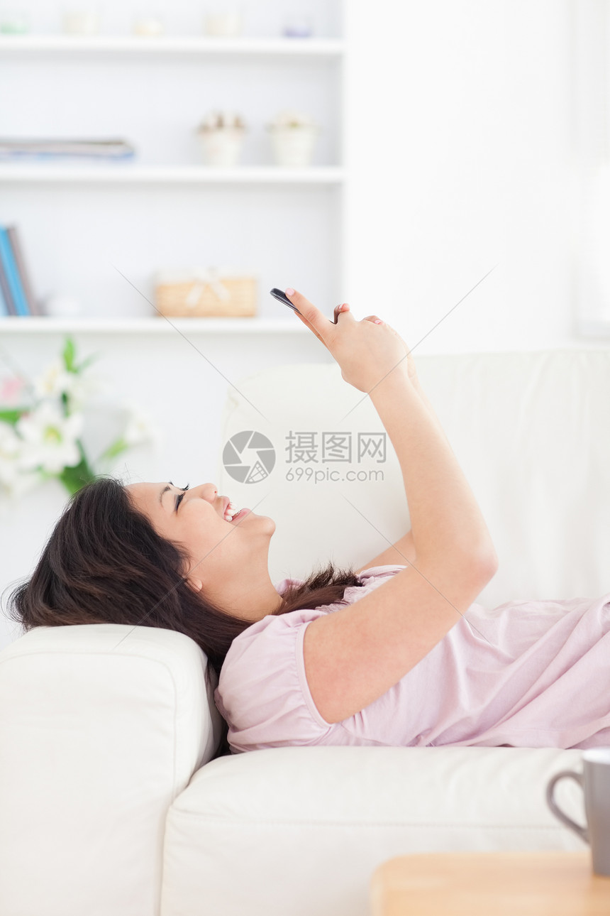 女人在睡沙发和看电话时笑着笑图片