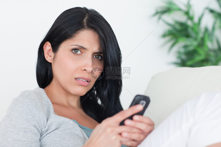 女人在沙发上休息时拿着电话图片